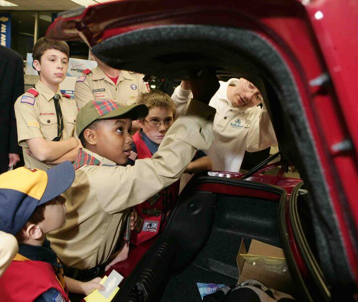 Cub Scout Bruce Powe learns how to pull the trunk-release latch on a 2007 Chevrolet Impala as fellow scouts Hal Baker (left rear) and Robbie Stoner (right rear) look on behind him at Cauley Chevrolet in West Bloomfield, Michigan Tuesday, October 24, 2006. Chevrolet is partnering with Safe Kids Worldwide and the Cub Scouts to…