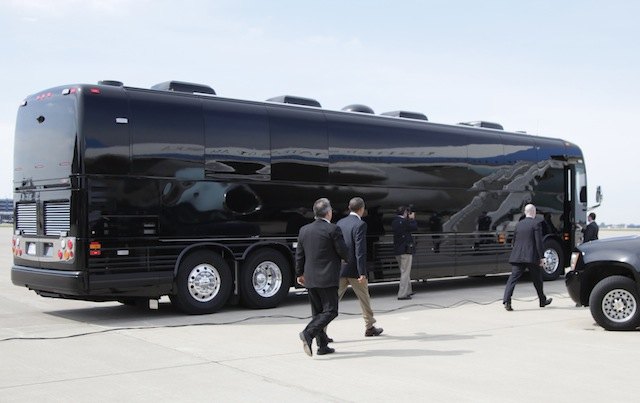 President Barack Obama boards his bus as he arrives at Minneapolis-St. Paul International Airport on Air Force One, seen reflected in the side of the bus, Monday, Aug. 15, 2011, in St. Paul, Minn., to start his three-day economic bus tour. (AP Photo/Carolyn Kaster)