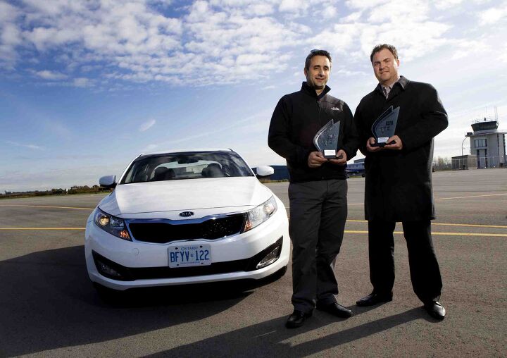 NIAGARA-ON-THE-LAKE: OCTOBER 28, 2011–Robert Staffieri, left, and Jack G. Sulymka, right, poses for a photo with the Kia Optima LX which won Best New Family Car (over $21,000) in the Automobile Journalists Association of Canada's TestFest 2012 Canadian Car of the Year Awards in Niagara-on-the-Lake on Friday, October 28, 2011. The Kia Optima Hybrid also…