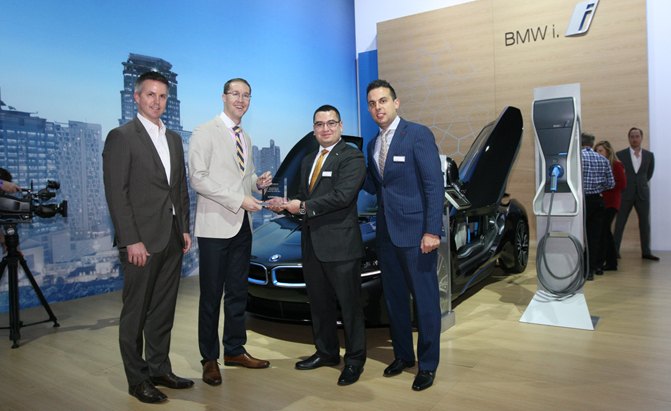 From left: VP of Sales Andy Jacobson and Editorial Director Colum Wood deliver the AutoGuide Reader's Choice Green Car of the Year Award to BMW's Jose Guerrero and Jacob Harb for the i8.