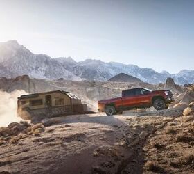 2024 GMC Sierra 2500HD AT4X towing a trailer through rocky mountain terrain.