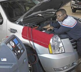 A Goodwrench technician checks under the hood for a regular maintenance check up