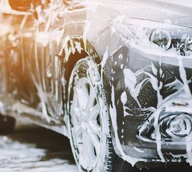Car Wash from Spray Gun with Foam Aimed at the Car Wheel Stock