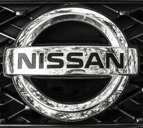 Nissan car logo on a front radiator grille of Nissan X-Trail SUV, closeup photo with selective focus