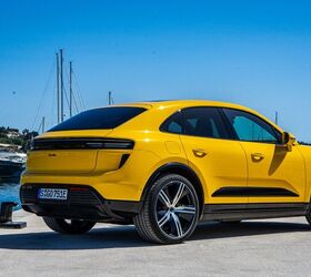 A yellow 2024 Porsche Macan Turbo EV sitting by the water on a nice sunny day. 